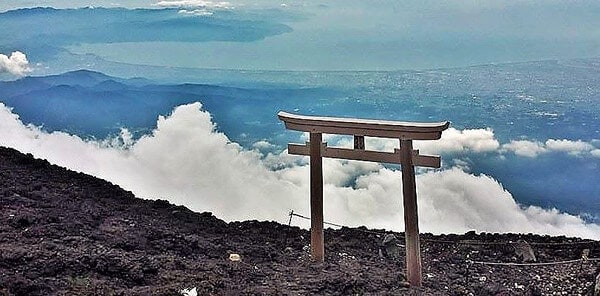View from the top of our climb up Mt. Fuji. A torii gate with clouds floating in the background
