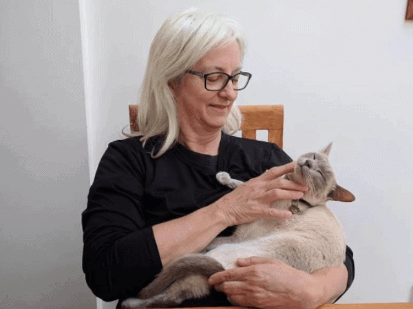 Photo of the author cuddling with a cat while house sitting