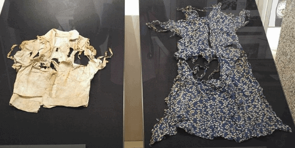 Torn and tattered white shirt and dress displayed at the Hiroshima Peace Memorial Museum