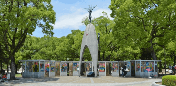 Stone monument to children with colorful paintings in the background