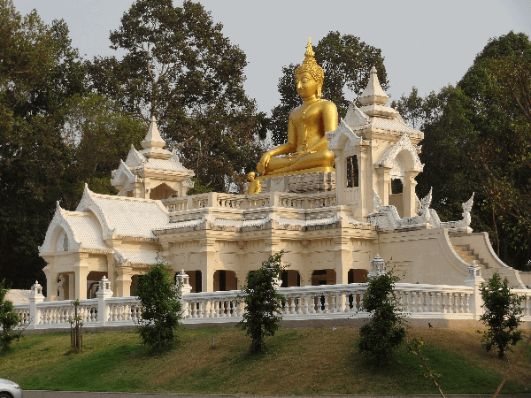 Picture of a golden Buddha on top of a white castle at the Ban Na Mueang temple in Thailand