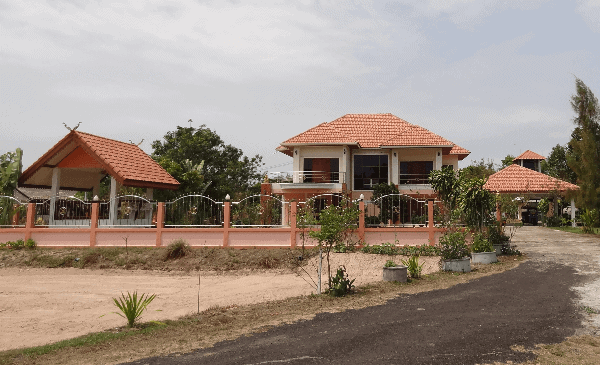 Picture of a fenced property and a large home with a tile roof