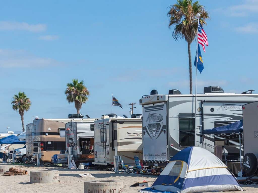 campers and a tent on a beach