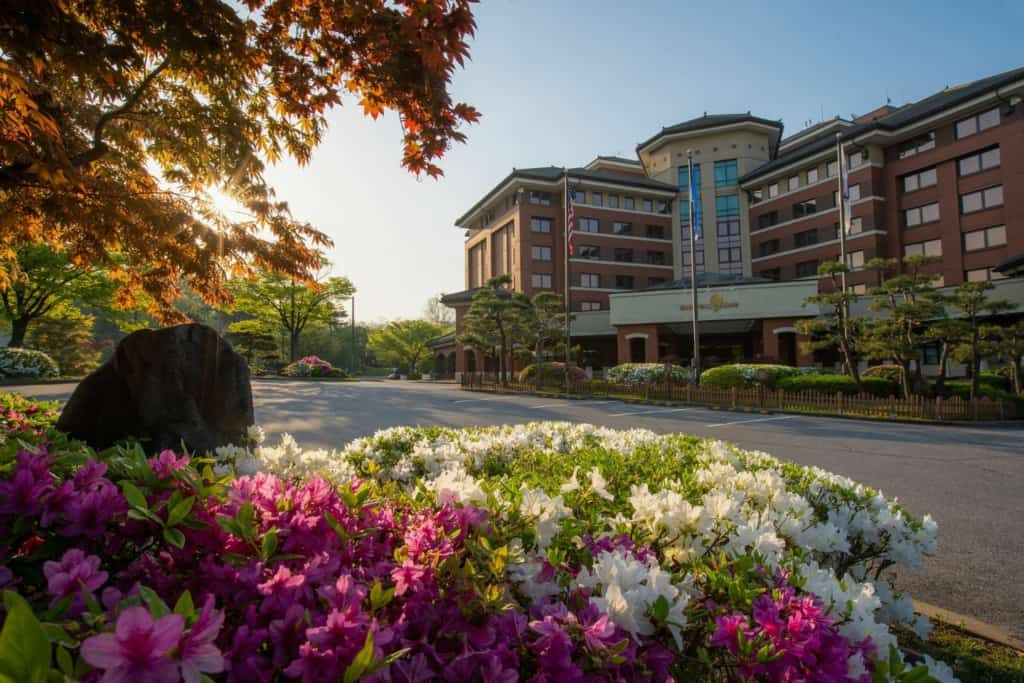 a stately brick hotel with colorful flowers in the foreground