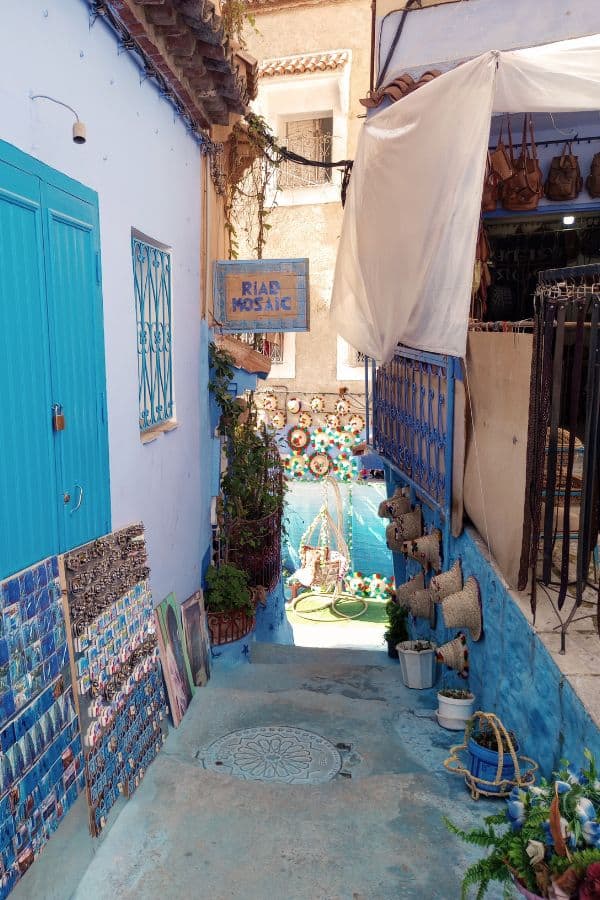 A narrow street with artisan crafts displayed on each side