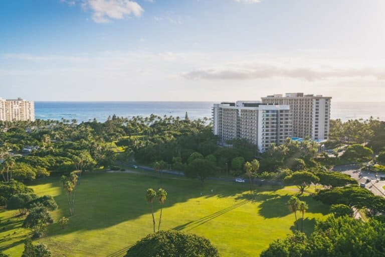 Aerial photo of an oceanfront hotel surrounded by greenery
