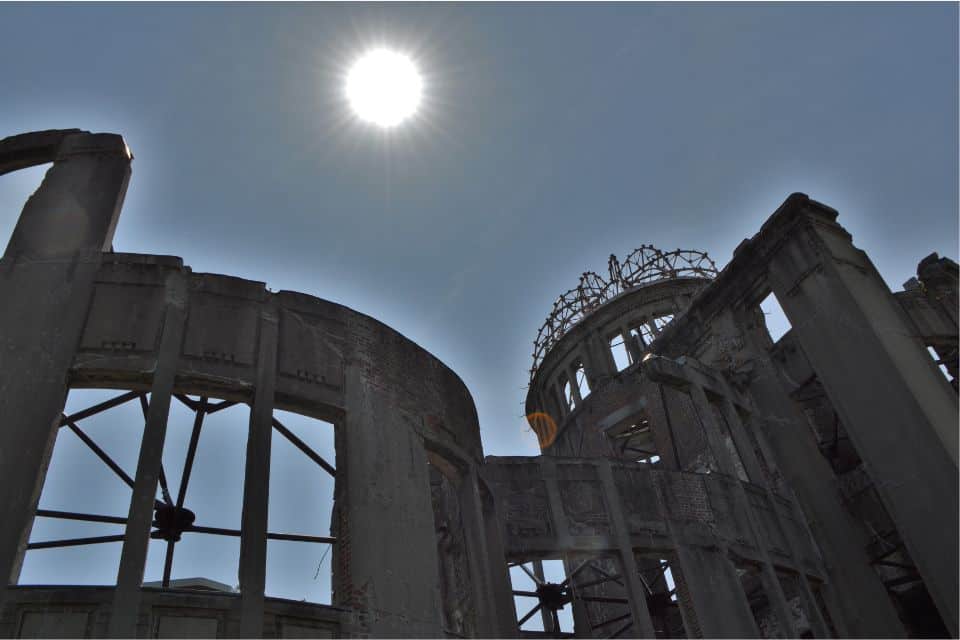 Rmains of the bomb dome and bright ball of sun in the background