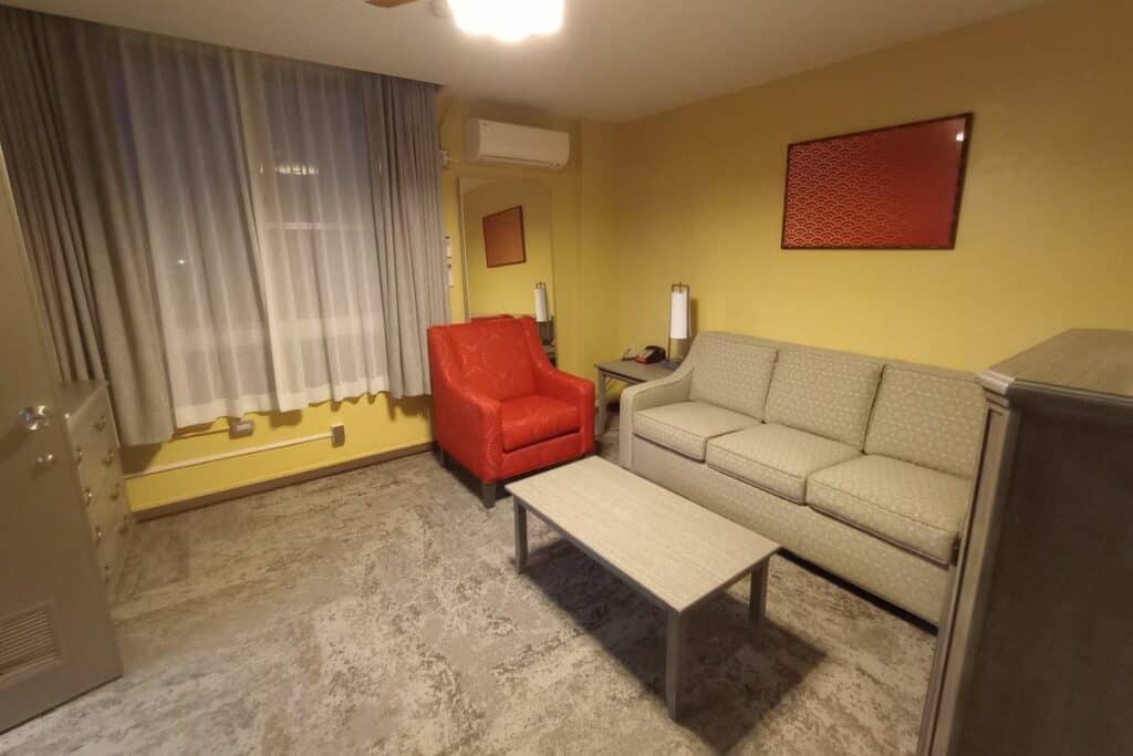 A room with couch and orange chair