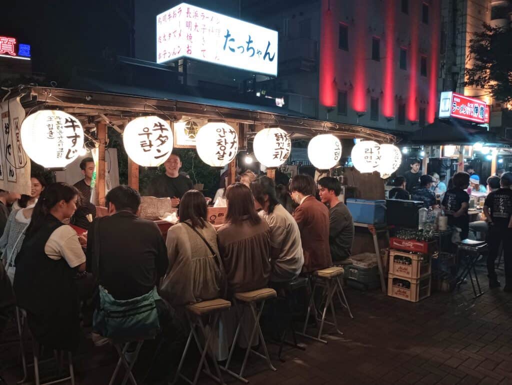 Guests sitting at an outdoor food stall in Japan