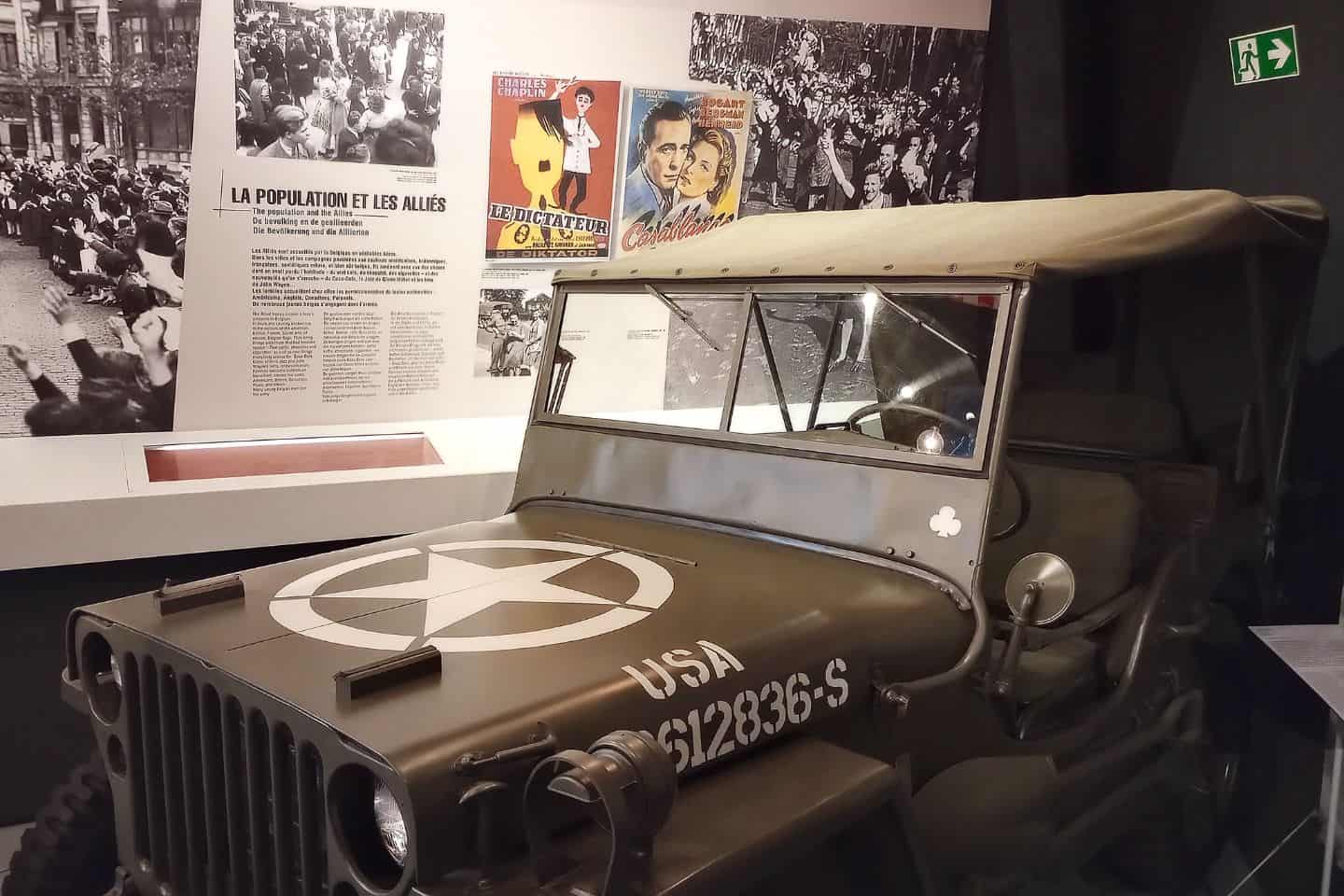 An old military jeep in front of a museum display