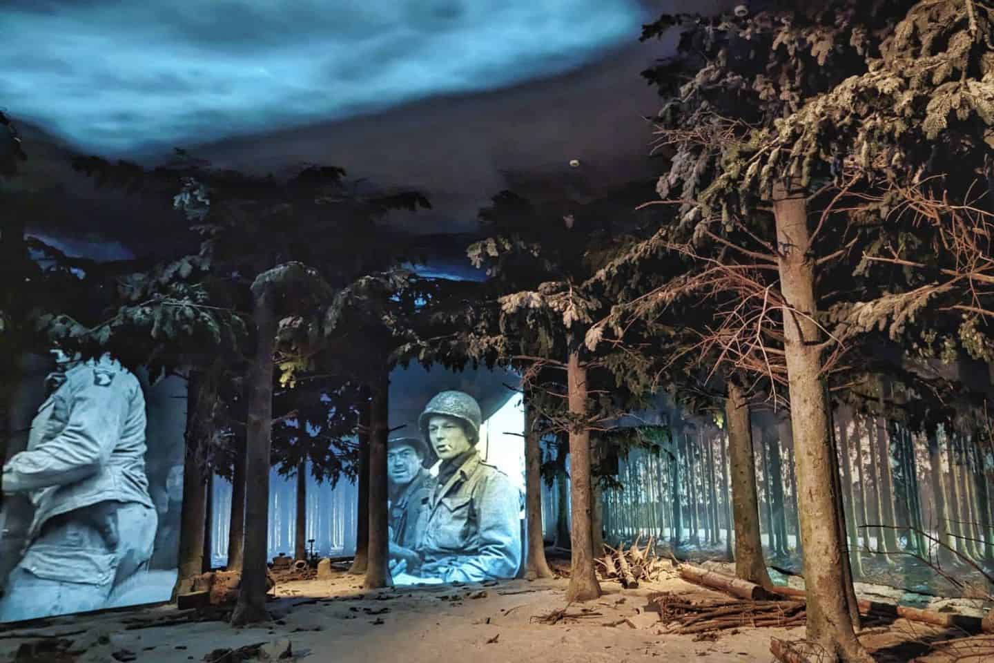 A war movie projected on a wall surrounded by trees
