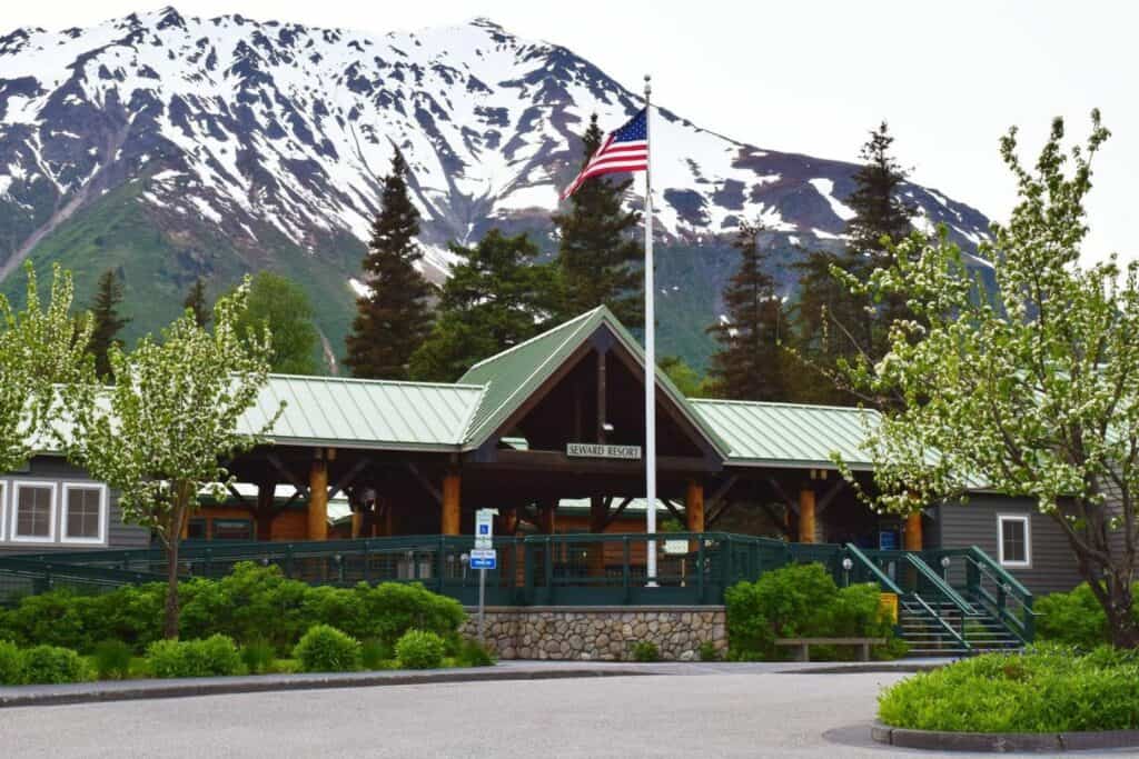 A building with a flag in front and mountains in the background