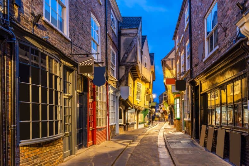 A narrow street with colorful storefronts at sunset