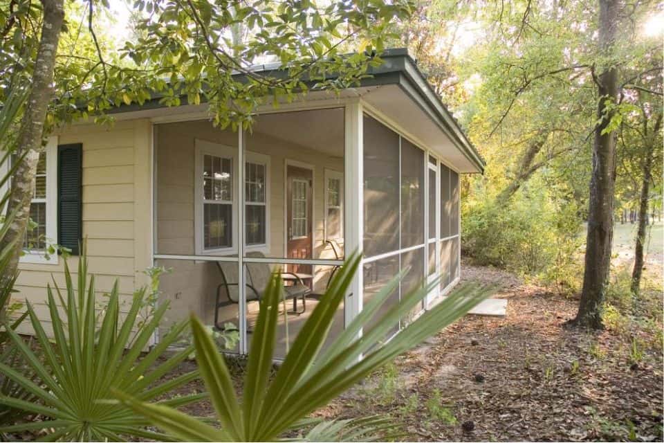 A yellow cottage with screened porch