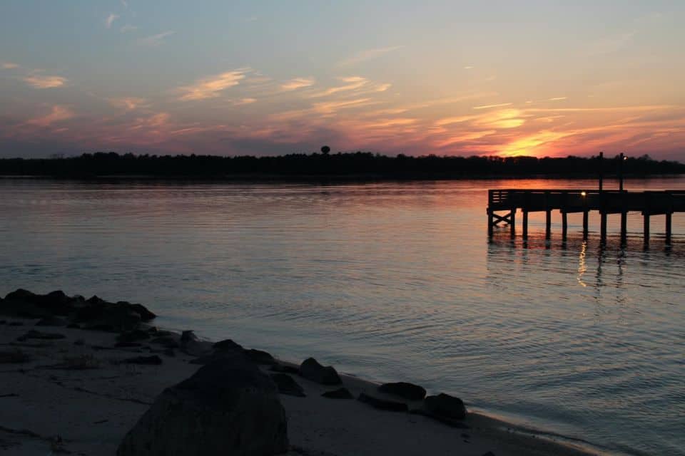 Sunset over a river with a dock