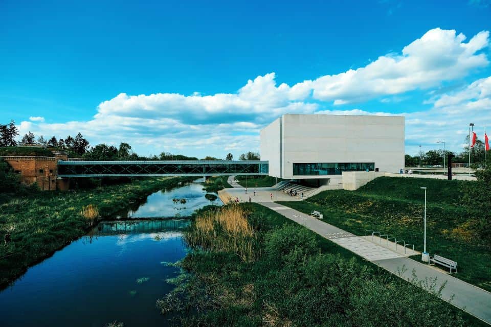 A modern building connected to a bridge over a river