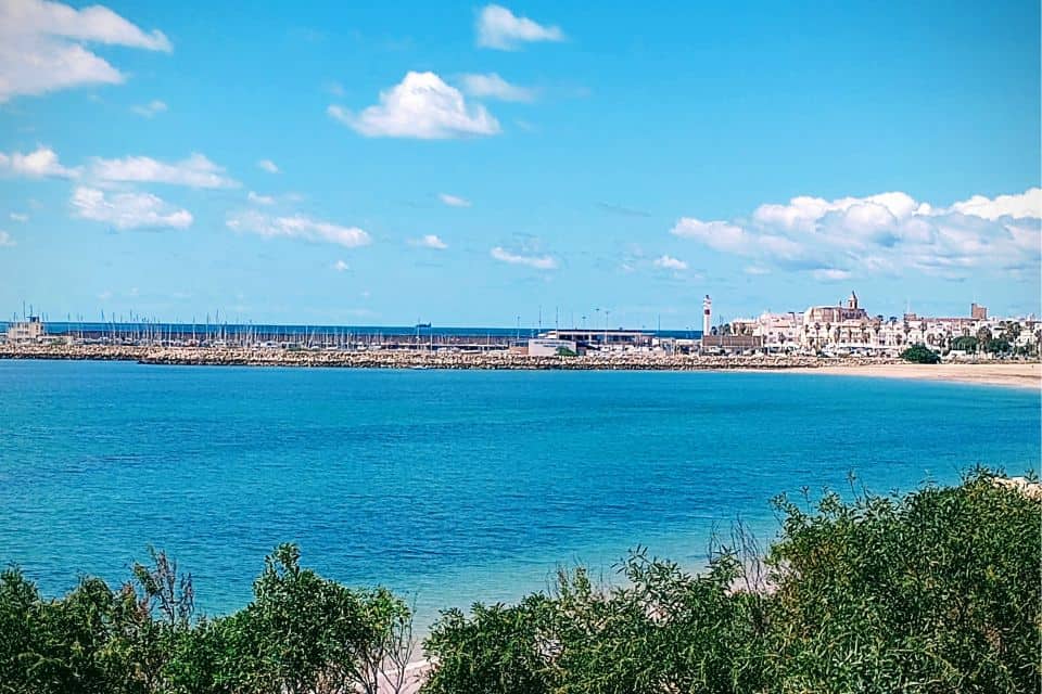 the rota skyline with boats in the marina, the lighthouse, and the beach