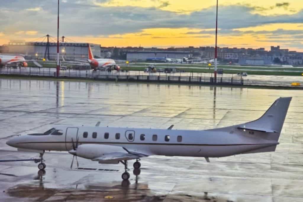 A small prop plane on a runway at sunrise