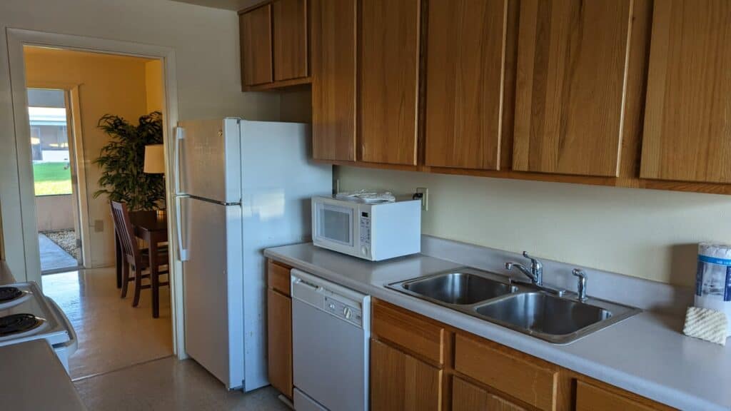 a kitchen with full refrigerator, microwave, dishwasher, and stove