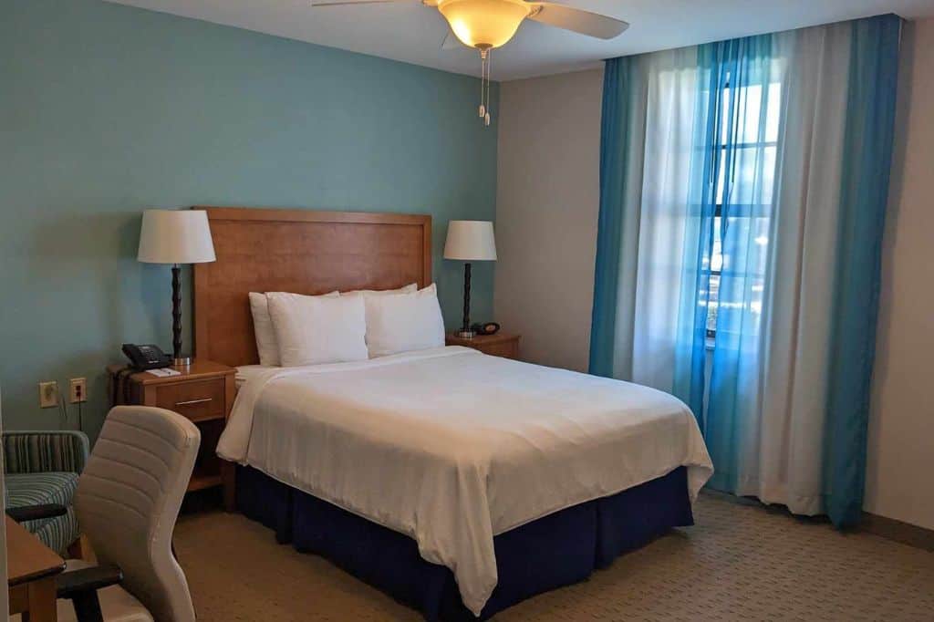 a hotel room with modern decor and transparent blue curtains
