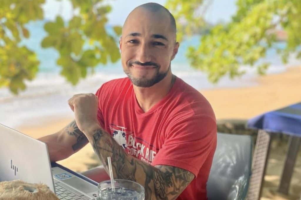 a veteran working at a laptop while sitting on the beach
