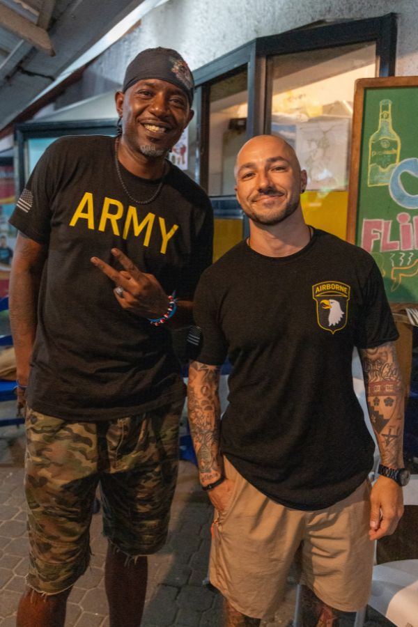 Two veterans smiling outside a local venue in the Dominican Republic.