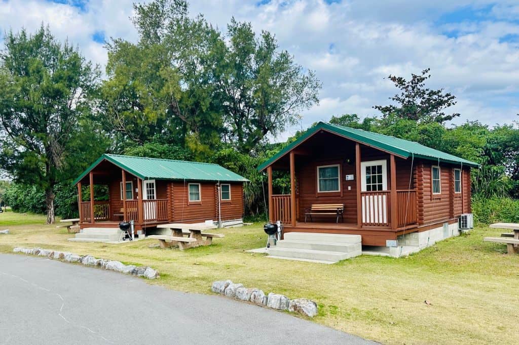 Two wooden cabins with green roofs