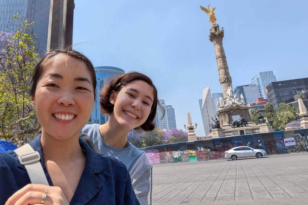 A woman and her daughter posing for a selfie in a square in mexico city