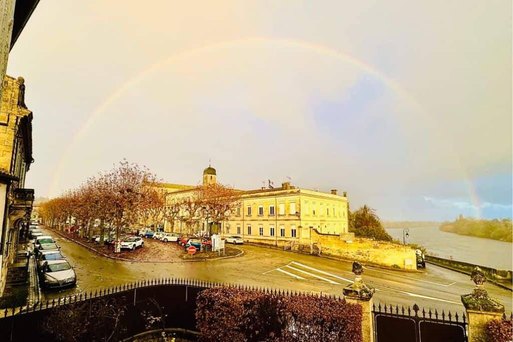 Rainbow arching over the riverside town of Castillon-la-Bataille, France