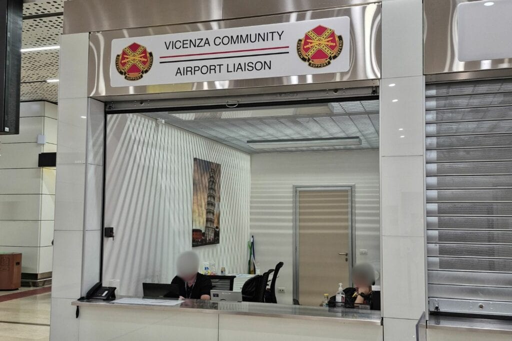 Vicenza Community Airport Liaison desk at Venice Marco Polo Airport, showing two staff members behind a counter