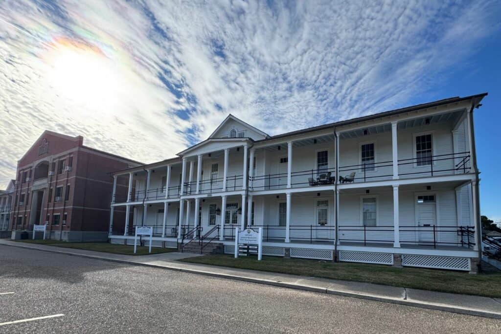 Historic white Jackson Barracks headquarters building with wraparound porches