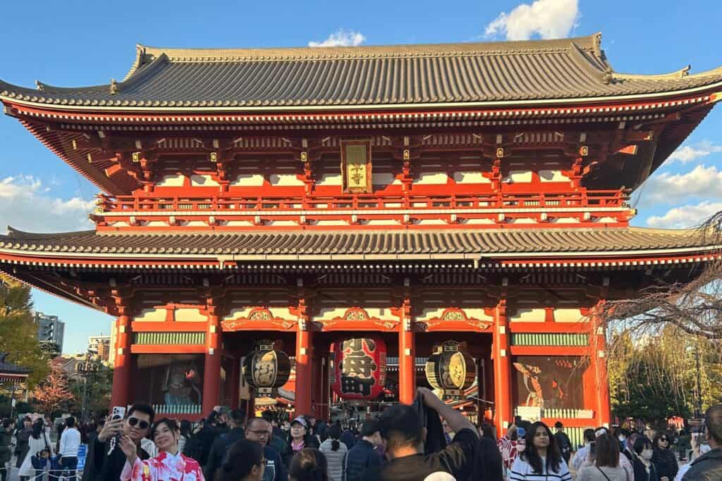 Crowds gathered at the bright red gate of Senso-ji Temple in Asakusa on a sunny afternoon
