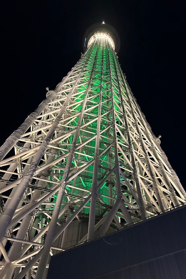 Tokyo Skytree illuminated at night, a towering steel observation tower rising above the city skyline.