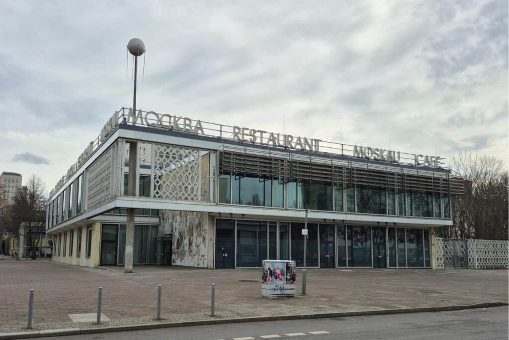 Modernist building with “Moskau Restaurant” sign on the roof and a distinctive Soviet-era design, including a replica of the Sputnik satelite on the roof
