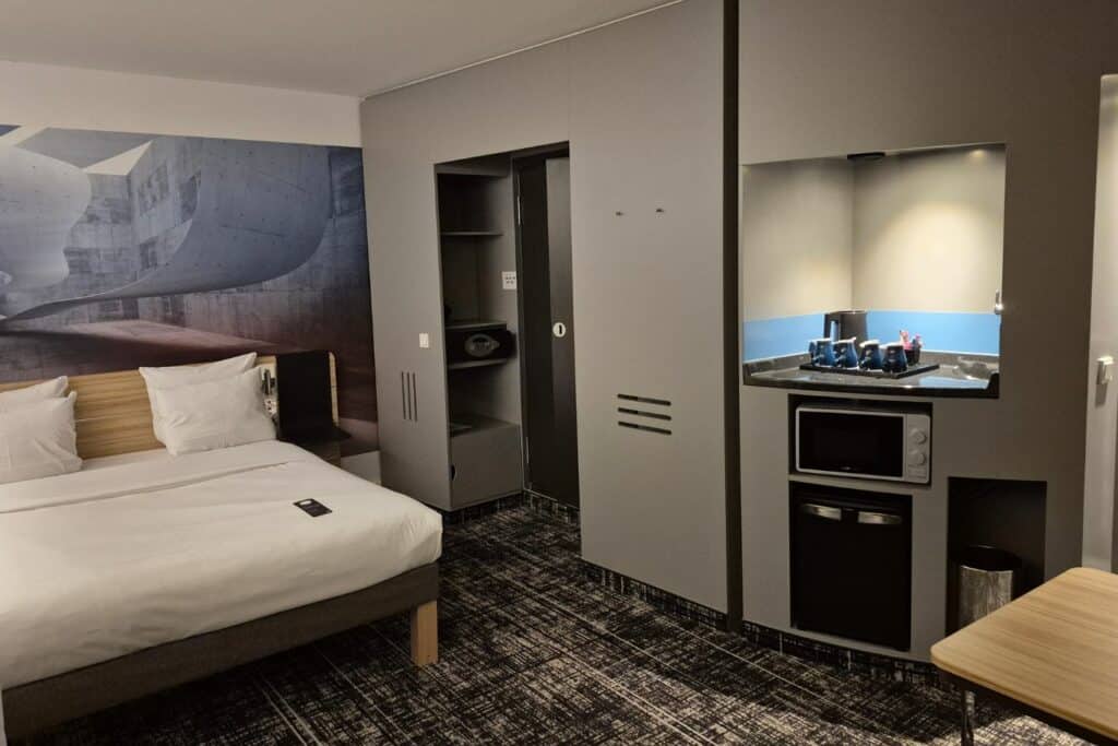 Large hotel room with bed, kitchenette, and seating area