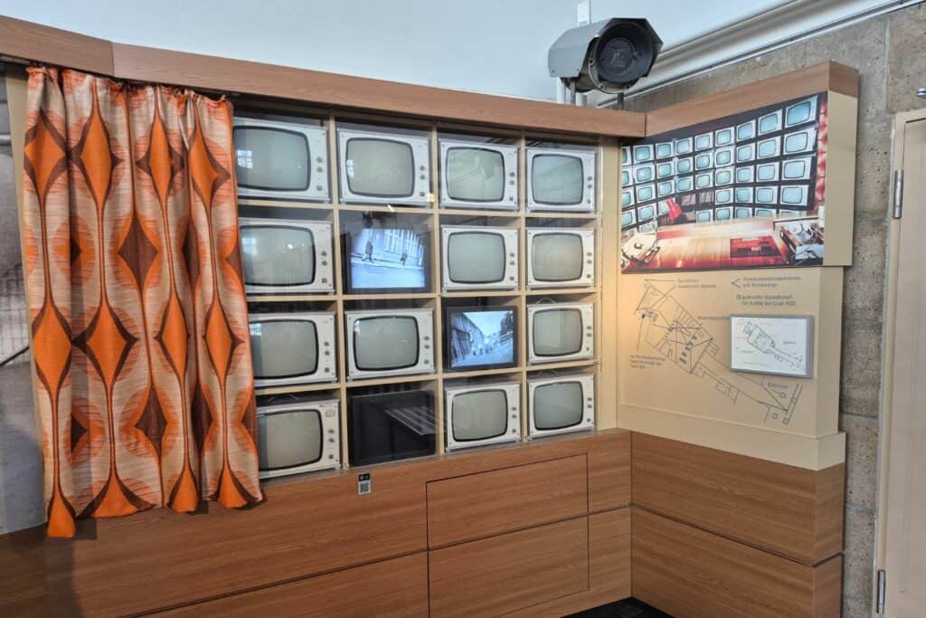 Wall of old television monitors and surveillance equipment display inside a museum