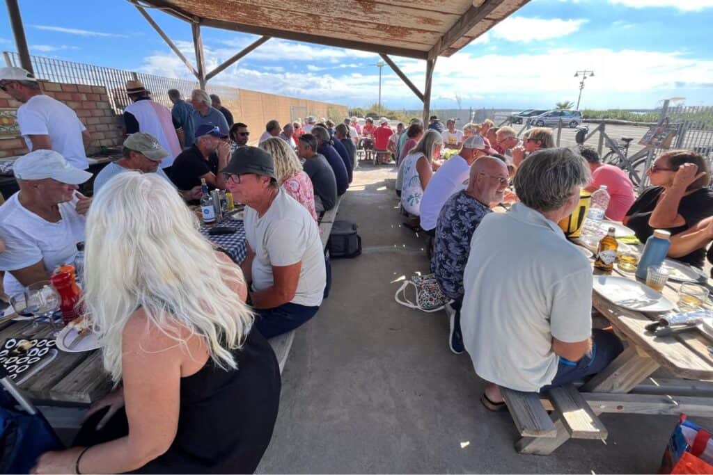 Cruisers gathered for an outdoor BBQ near the marina