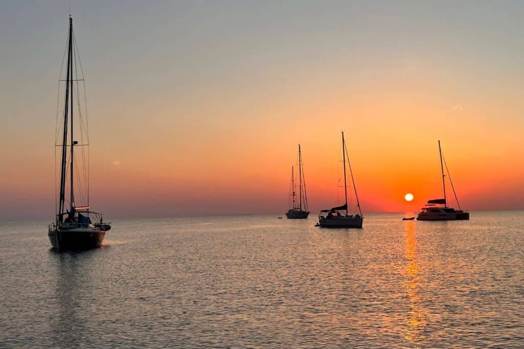 Sailboats anchored at sunset