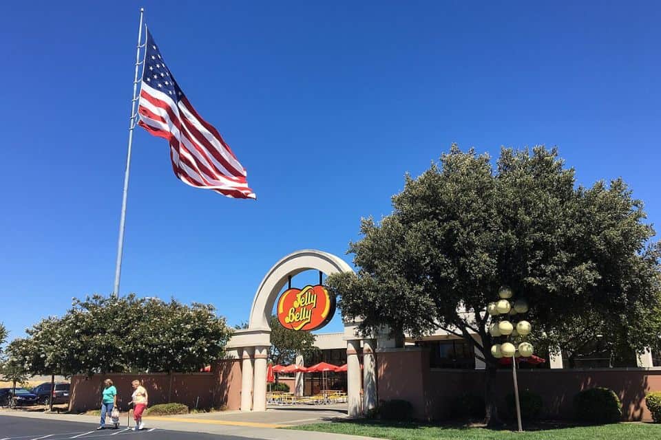 Entrance to the Jelly Belly Visitor Center with a large American flag flying above the building