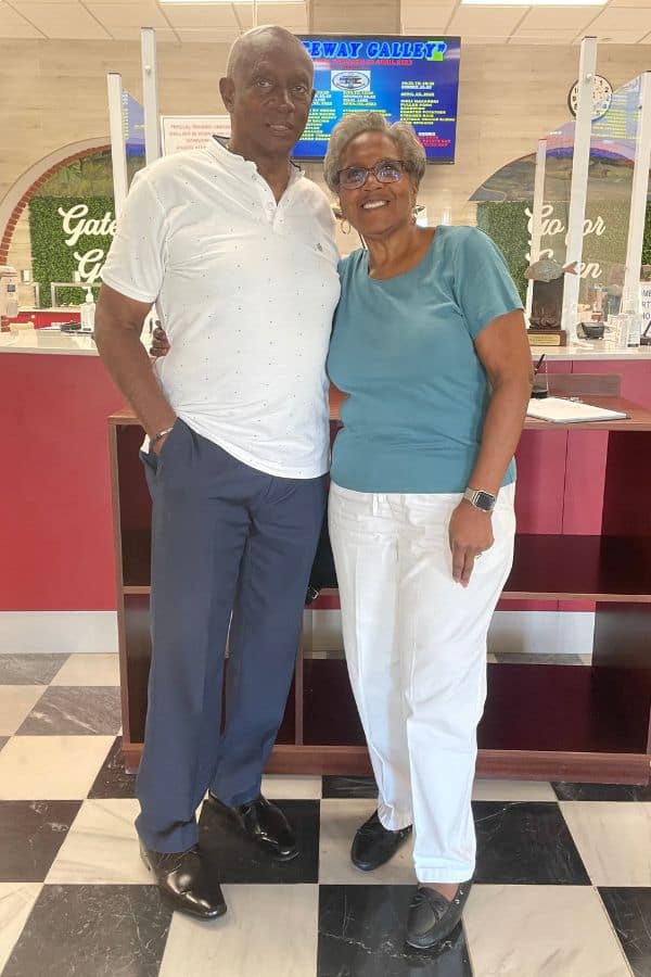 a couple standing in a dining facility with an electronic menu behind them