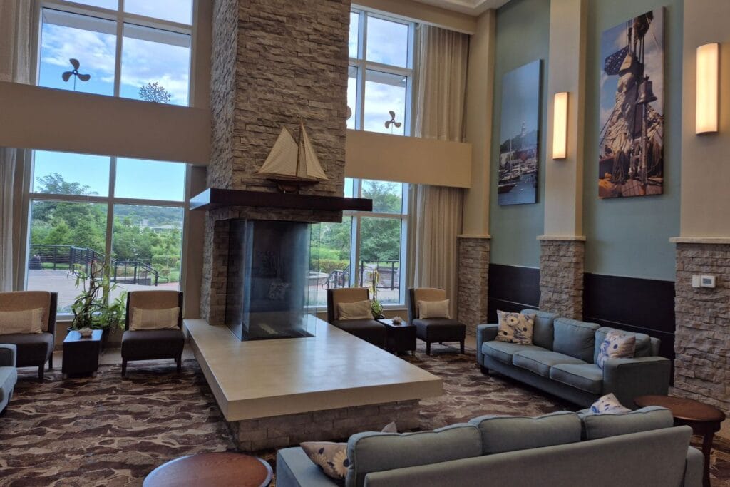 Modern Navy Inn lobby with a stone fireplace, sofas, chairs, and large windows