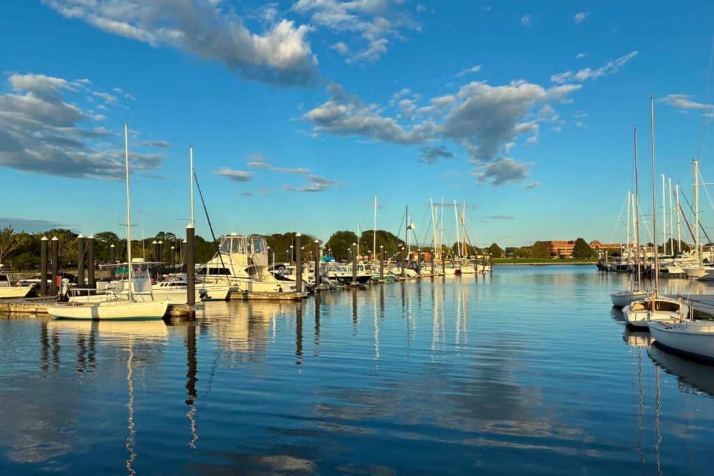 Sailboats and powerboats reflected in the calm water at the Naval Station Newport marina