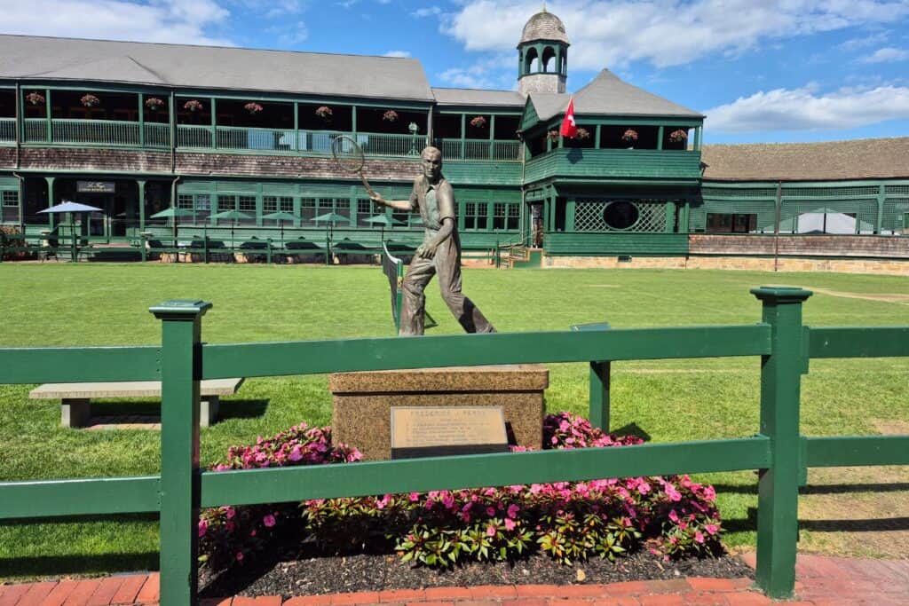 Grass tennis courts, a statue, and historic buildings at the International Tennis Hall of Fame