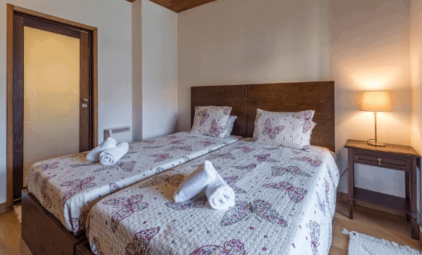 Two beds with rolled towels ready for guests in our Airbnb Porto