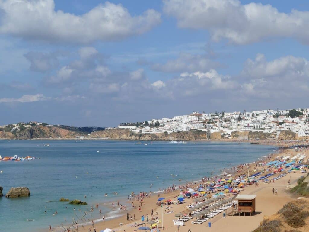 Aerial view of a crowded beach with colorful umbrellas