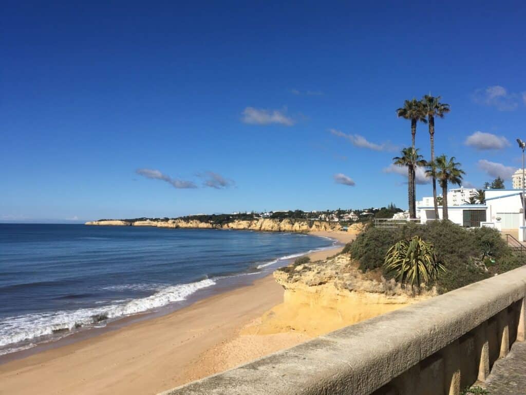 A beach viewed over the balcony of a boardwalk