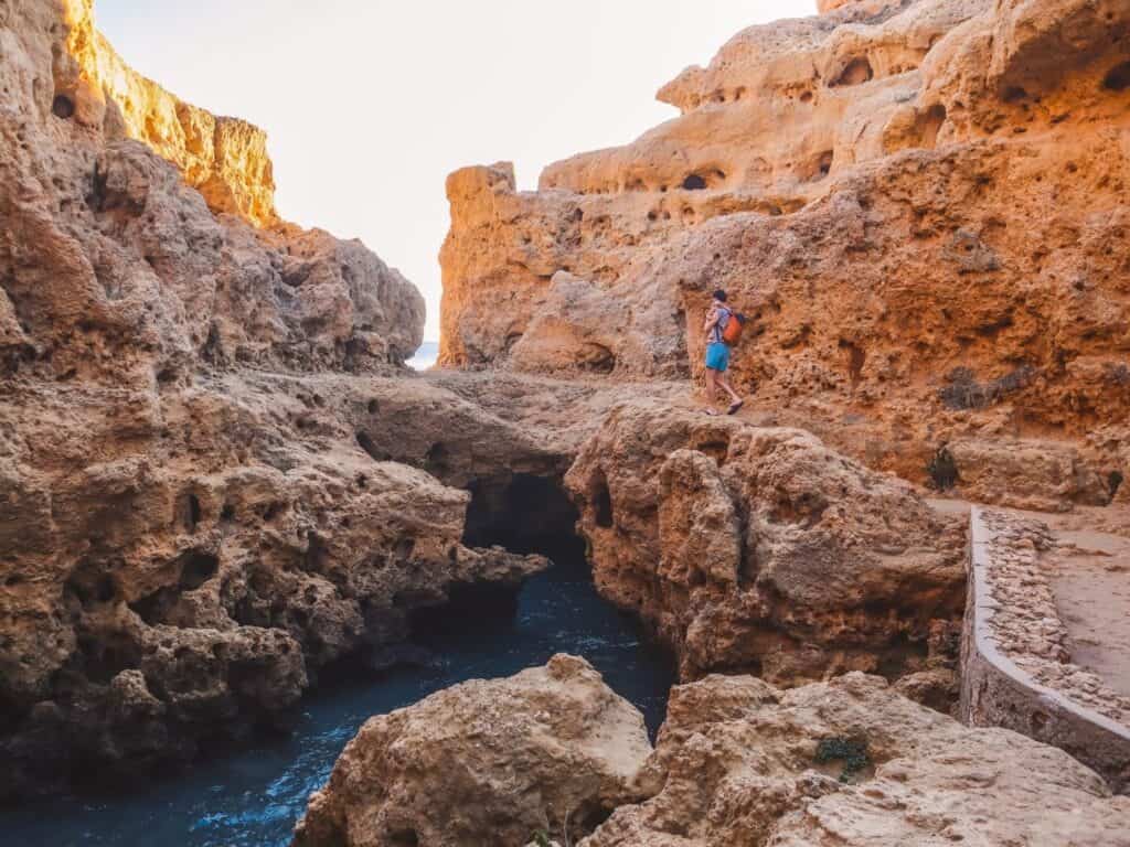 A person walking along waterfront cliffs