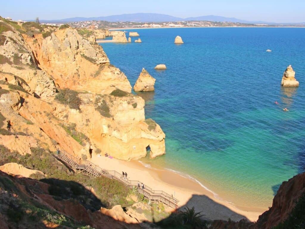 Cliffs and rock formations next to a beach with turquoise water