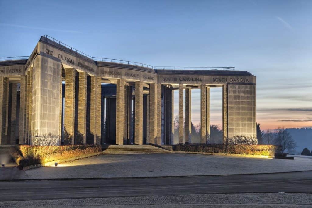 A World War II memorial with stone columns at dusk