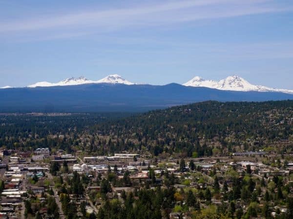 Treetop views with snow-capped mountains in the background - book a winter rental in Bend, OR